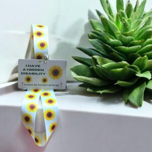 White sunflower-themed lanyard with attached waterproof ID card displayed next to a succulent on white background.
