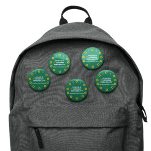 Green 5-pack of hidden disability awareness pins on a backpack